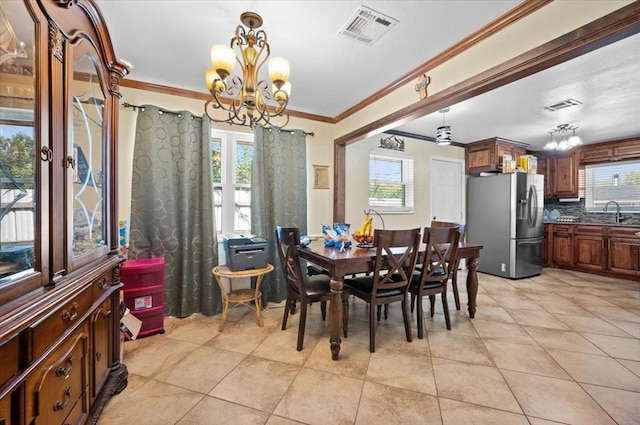 tiled dining space featuring crown molding, sink, and a chandelier