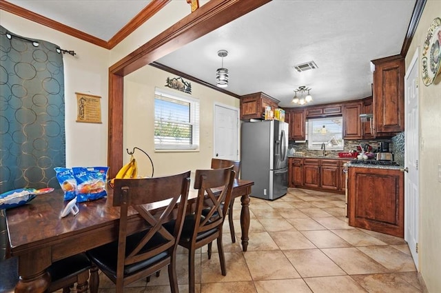 dining area with sink, light tile patterned floors, and ornamental molding