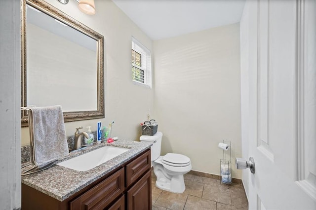 bathroom with tile patterned flooring, vanity, and toilet