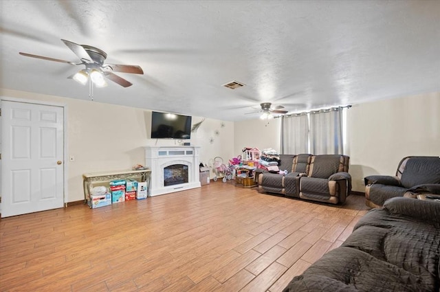 living room with ceiling fan and light wood-type flooring