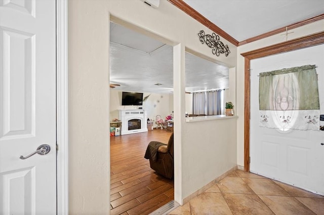 entryway with crown molding and light hardwood / wood-style flooring