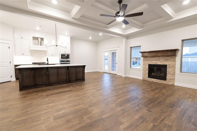 kitchen with dark wood-style floors, a large island, open floor plan, built in microwave, and light countertops