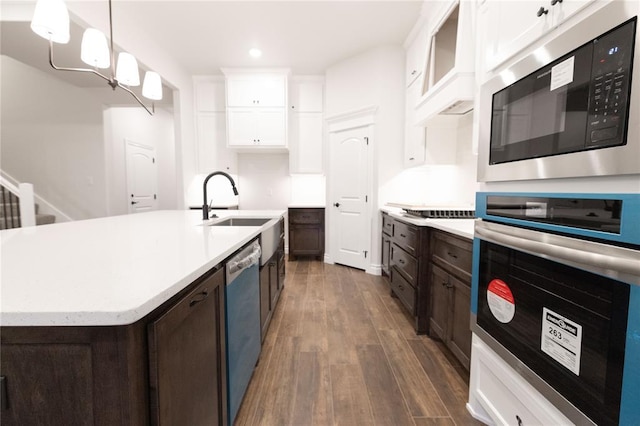 kitchen featuring stainless steel appliances, light countertops, dark wood-type flooring, white cabinets, and dark brown cabinets