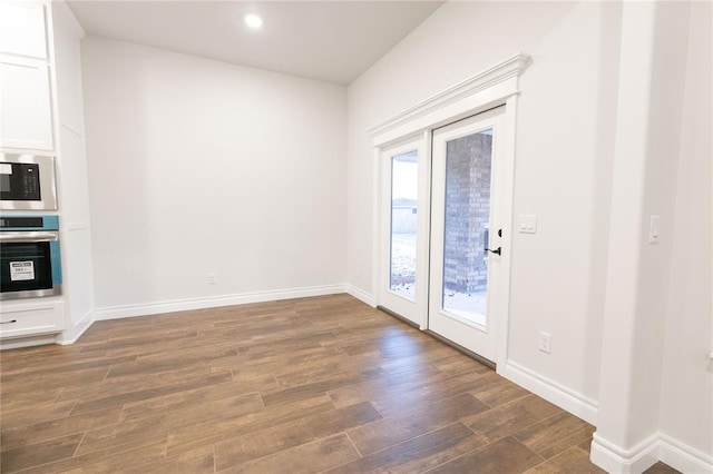 doorway featuring baseboards, dark wood-style flooring, and recessed lighting