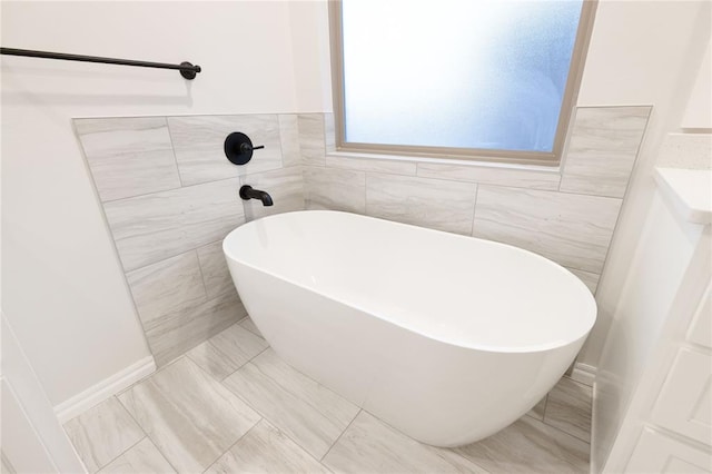 full bath featuring a freestanding bath and tile walls