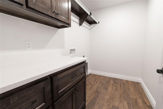 laundry area featuring hookup for a washing machine, baseboards, cabinet space, dark wood-style floors, and electric dryer hookup