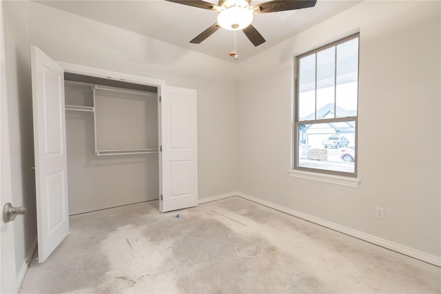 unfurnished bedroom featuring baseboards, a closet, concrete flooring, and ceiling fan