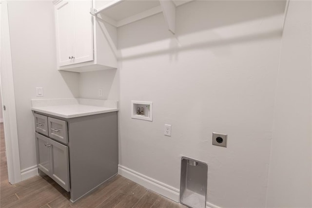 washroom with cabinet space, hookup for an electric dryer, dark wood-type flooring, and washer hookup