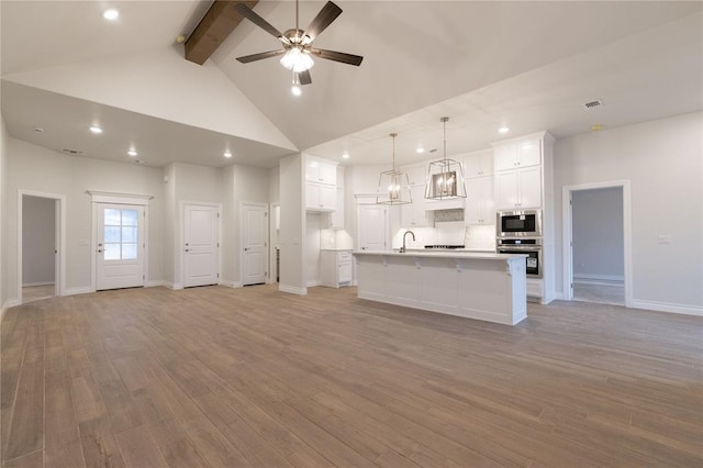 unfurnished living room with beam ceiling, light wood-style flooring, high vaulted ceiling, and a ceiling fan