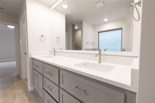 bathroom with a sink, recessed lighting, and double vanity