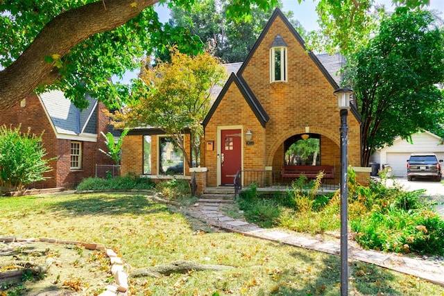 english style home with a garage and a front lawn