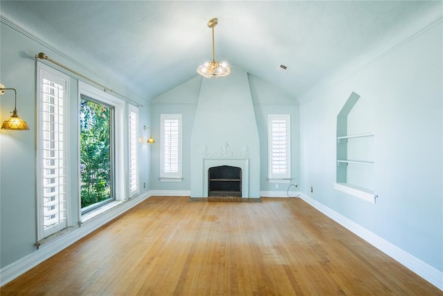 unfurnished living room with built in shelves, a large fireplace, light hardwood / wood-style flooring, and vaulted ceiling