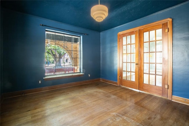 empty room with french doors and hardwood / wood-style flooring