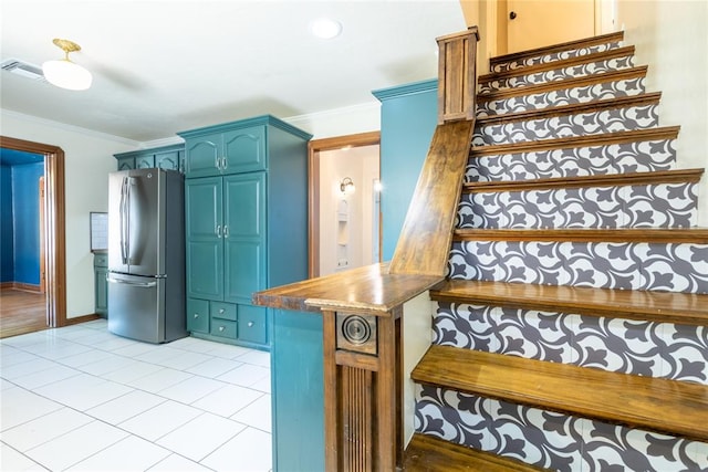 stairs featuring tile patterned floors and crown molding