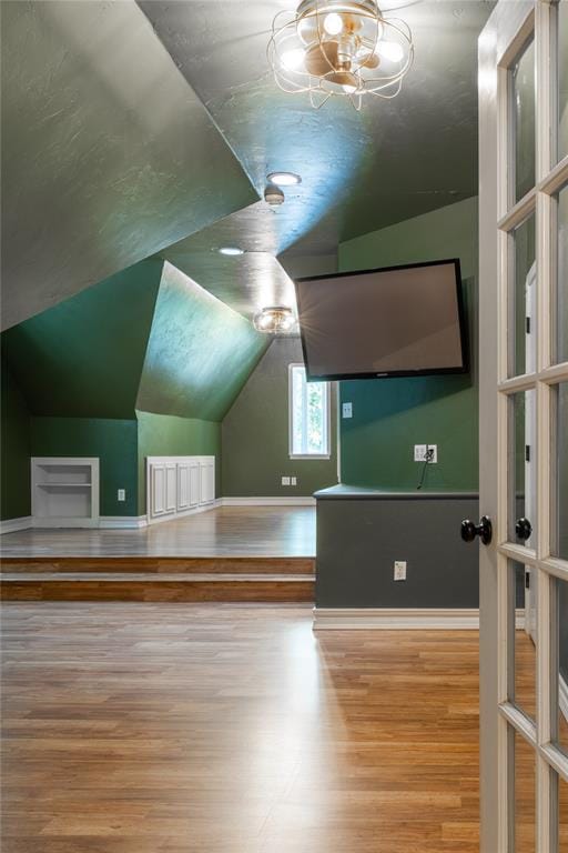 additional living space with vaulted ceiling and hardwood / wood-style flooring