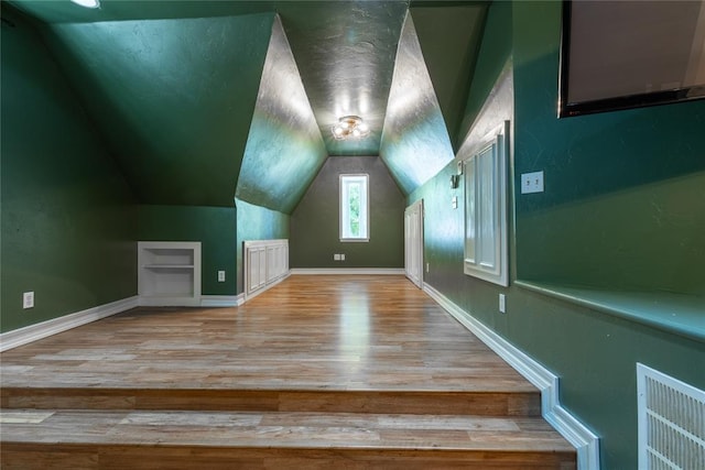 bonus room featuring lofted ceiling and light hardwood / wood-style flooring