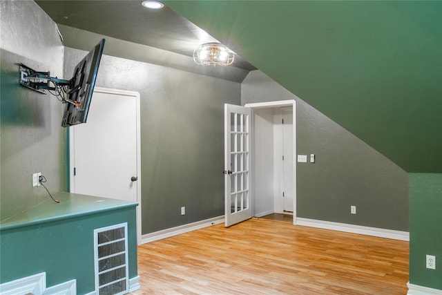 additional living space featuring hardwood / wood-style flooring and lofted ceiling