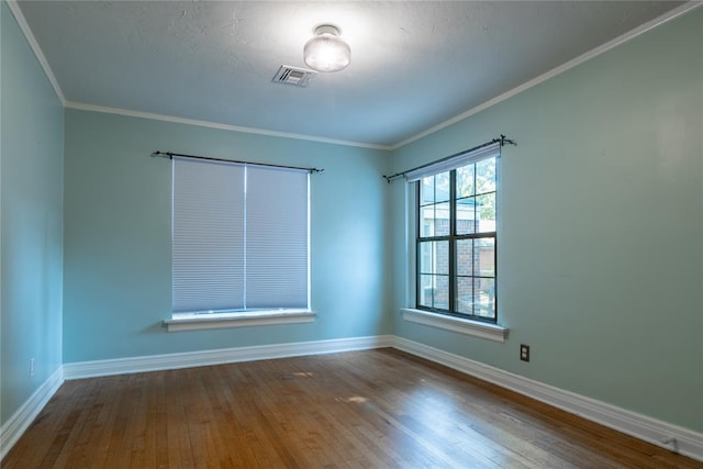 empty room with wood-type flooring and crown molding