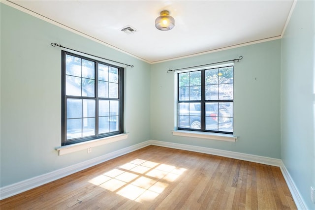 empty room featuring light hardwood / wood-style floors and crown molding