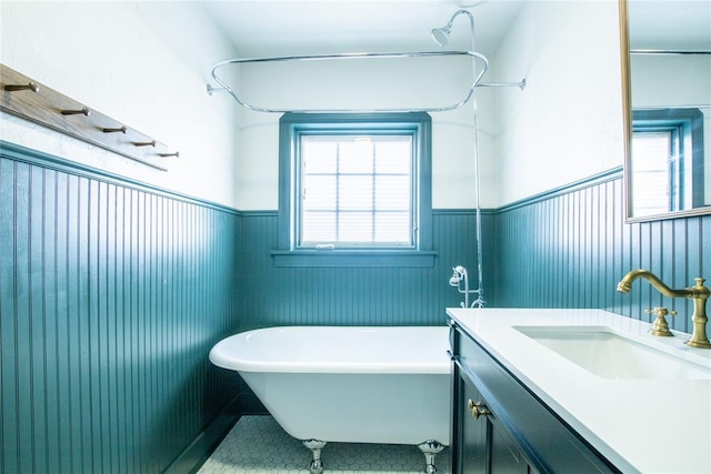 bathroom featuring a tub, wooden walls, tile patterned flooring, and vanity