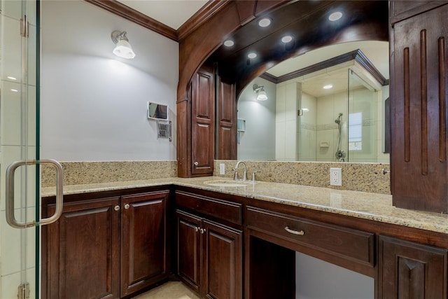 bathroom with crown molding, vanity, and an enclosed shower