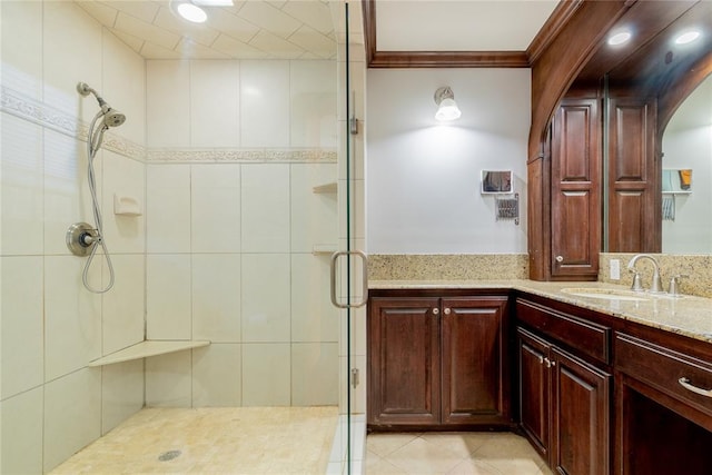 bathroom with vanity, an enclosed shower, ornamental molding, and tile walls