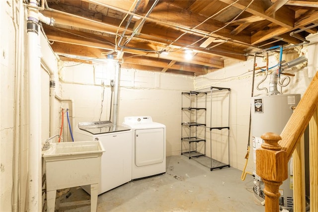 laundry area featuring washing machine and clothes dryer, sink, and water heater