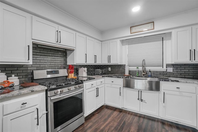 kitchen with gas range, tasteful backsplash, white cabinetry, and sink