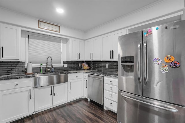 kitchen with appliances with stainless steel finishes, crown molding, dark wood-type flooring, sink, and white cabinets