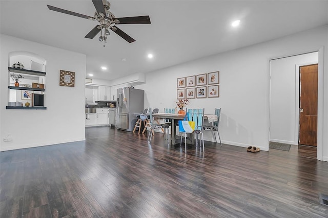 dining space with ceiling fan, dark wood-type flooring, and sink