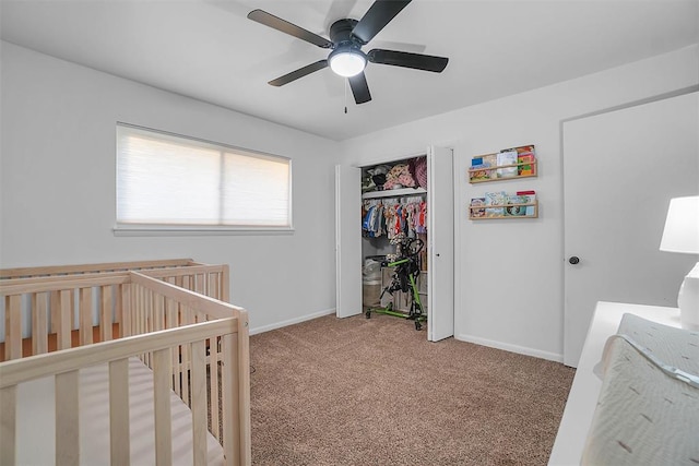 carpeted bedroom with a nursery area, a closet, and ceiling fan