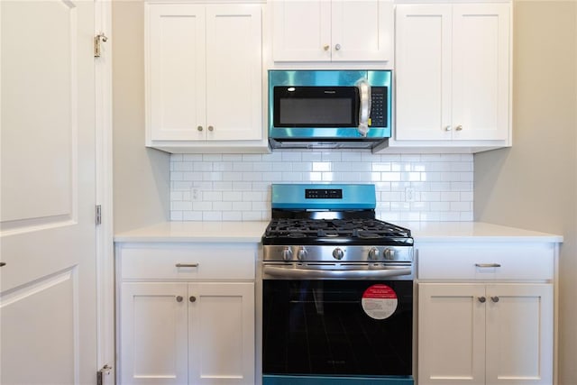 kitchen featuring light countertops, appliances with stainless steel finishes, white cabinetry, and tasteful backsplash