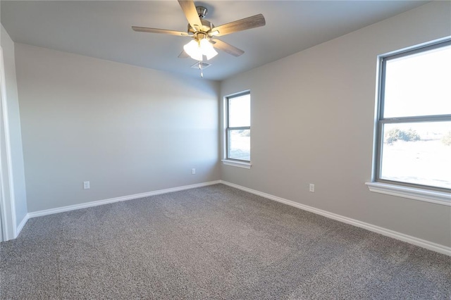 carpeted empty room with a ceiling fan and baseboards