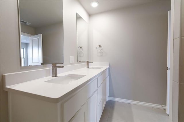 full bathroom with double vanity, a sink, visible vents, and baseboards