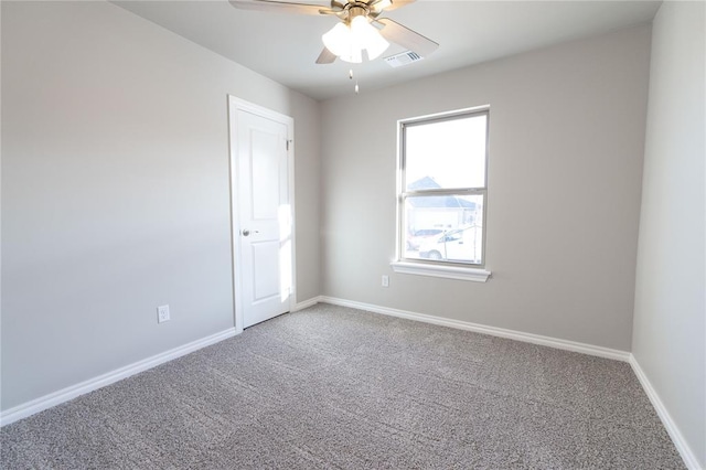 spare room featuring a ceiling fan, carpet, visible vents, and baseboards