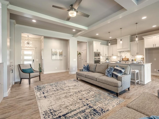 living room with light hardwood / wood-style flooring, ceiling fan, ornamental molding, and sink