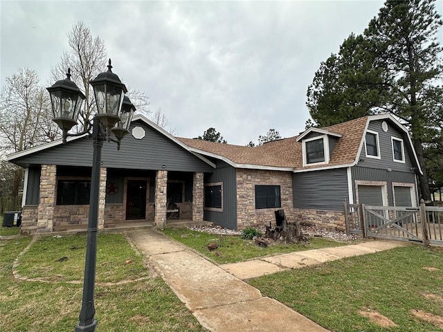 view of front facade with covered porch, a garage, a front lawn, and cooling unit