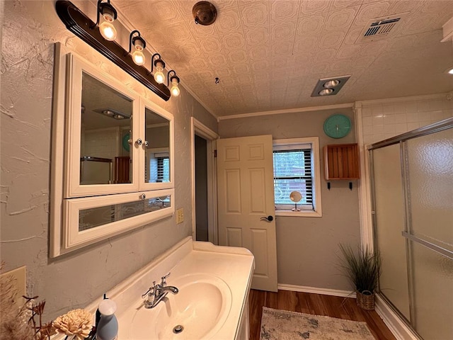 bathroom with hardwood / wood-style floors, vanity, ornamental molding, and walk in shower