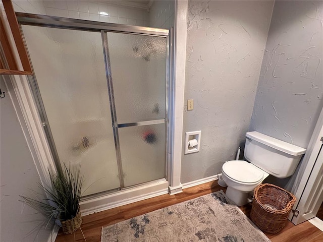 bathroom with toilet, wood-type flooring, and walk in shower