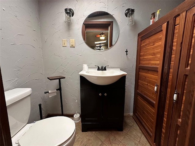 bathroom featuring tile patterned floors, vanity, and toilet