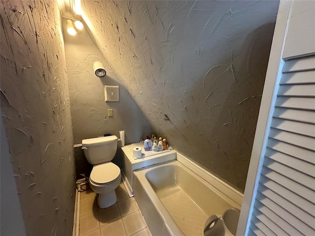 bathroom with a tub, tile patterned flooring, and toilet