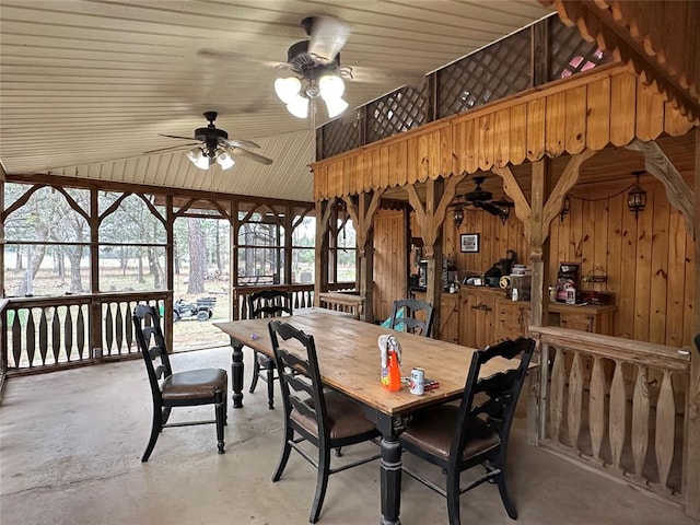 dining room featuring wooden ceiling, ceiling fan, lofted ceiling, and wood walls