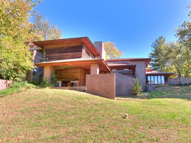 rear view of house featuring a lawn