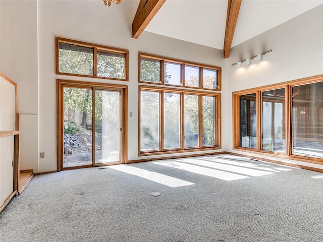 unfurnished living room with beamed ceiling, carpet floors, and high vaulted ceiling