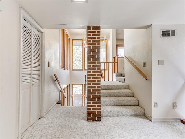 stairs with a healthy amount of sunlight and carpet floors