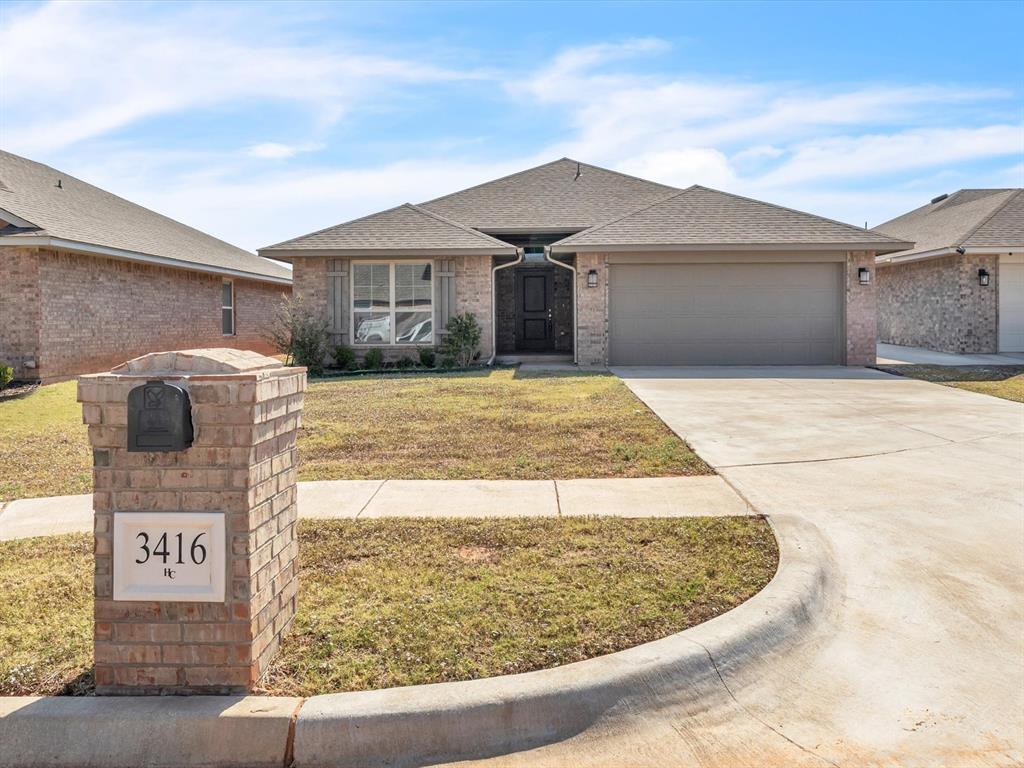 single story home featuring a front lawn and a garage