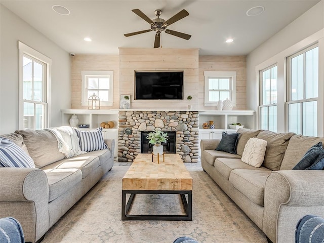 living room with ceiling fan and a fireplace