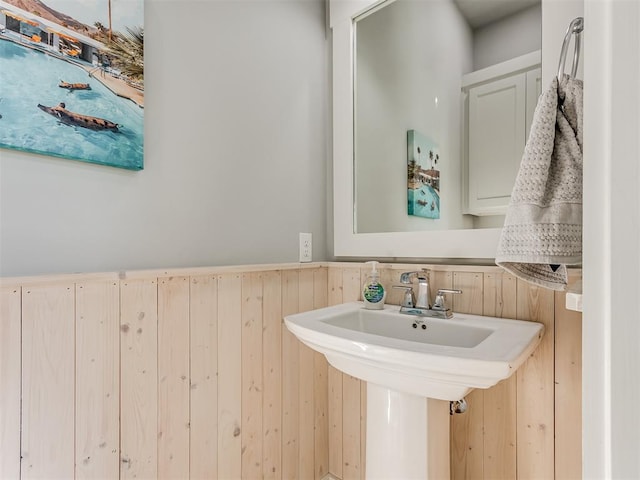 bathroom featuring wood walls and sink