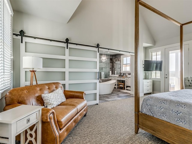 bedroom with multiple windows, carpet, and a barn door