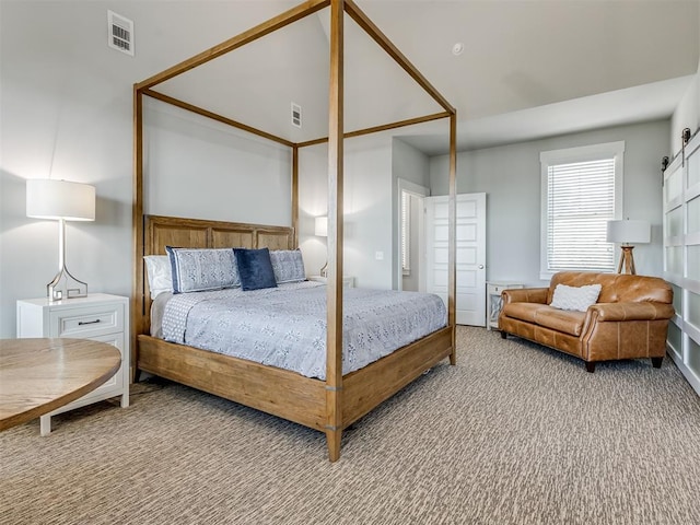 carpeted bedroom with a barn door